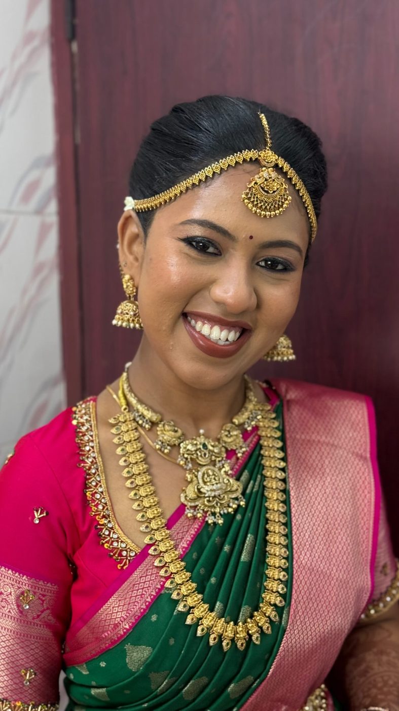 Bride in pink and green silk saree with gold jewellery