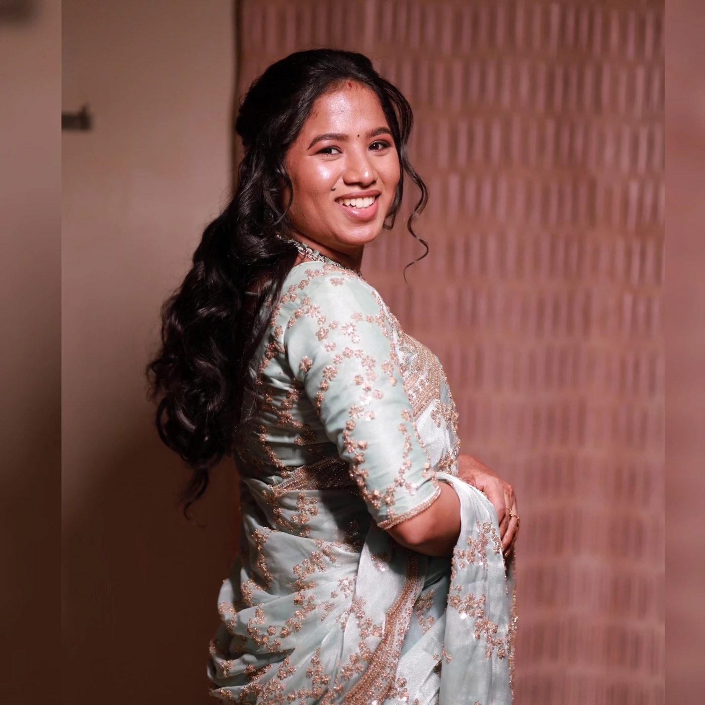 Woman with long curls in pastel saree